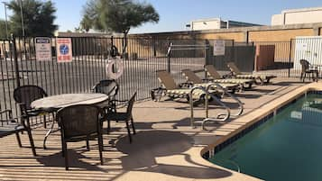 Una piscina al aire libre de temporada, sombrillas