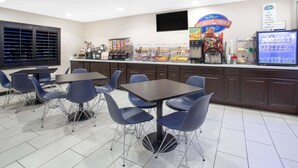 A breakfast area with a counter, seating, and a refrigerator. - Baymont by Wyndham Phoenix I-10 near 51st Ave (Phoenix)