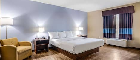 A hotel room with a bed, nightstands, a lamp, a chair, and a window with curtains.