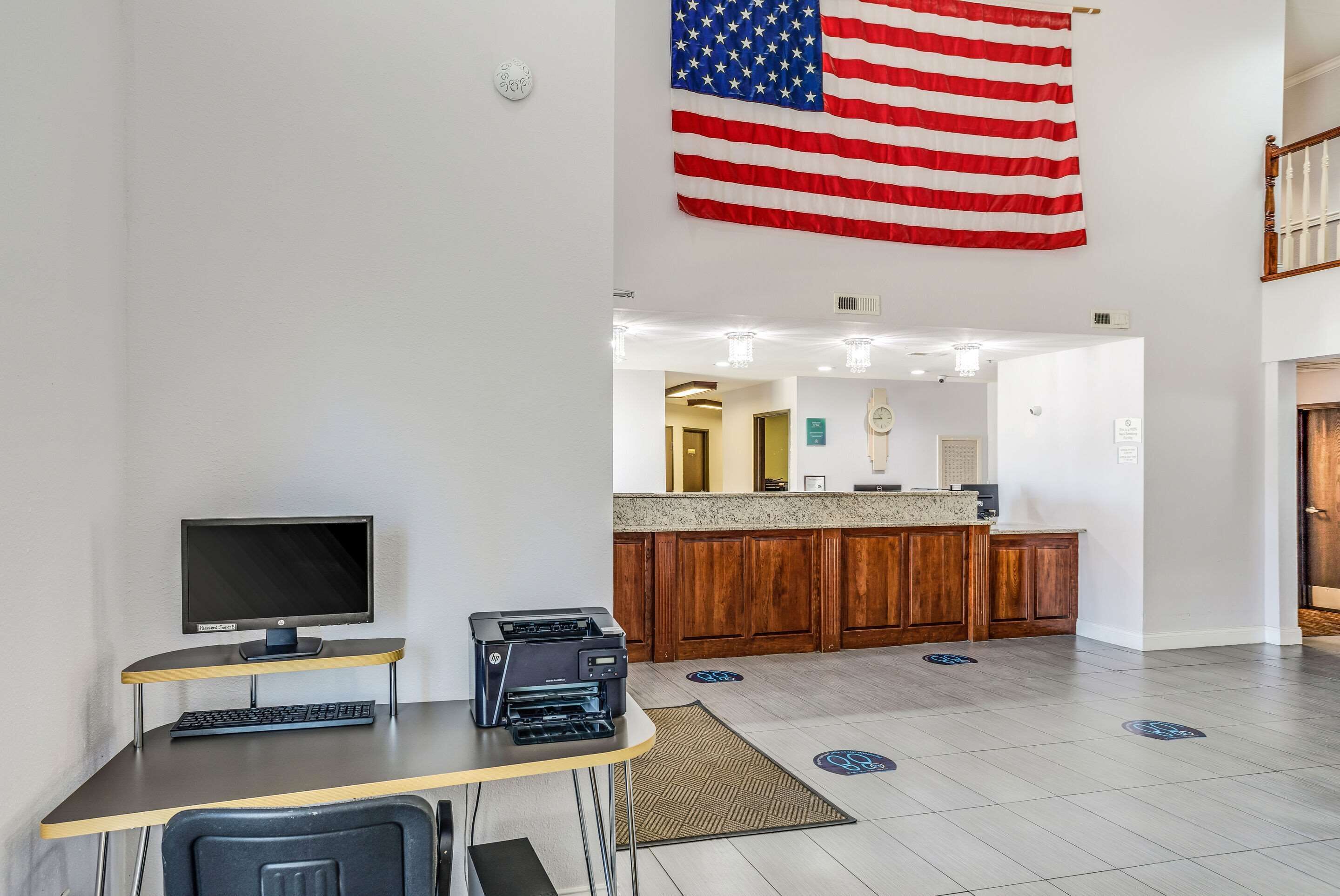 Een receptiezone met een balie, computer, printer en een Amerikaanse vlag.