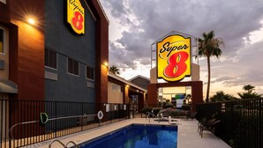 A hotel with a swimming pool, outdoor seating, and a large 'Super 8' sign. - Super 8 by Wyndham Marana/Tucson Area (Tucson)