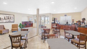 Un vestíbulo de hotel con recepción, zona de estar y estación de café.