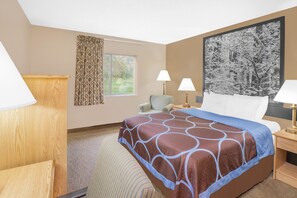 A hotel room with a large bed, two bedside lamps, a chair, a window with curtains, and a framed picture on the wall. - Super 8 by Wyndham Seville (Seville)