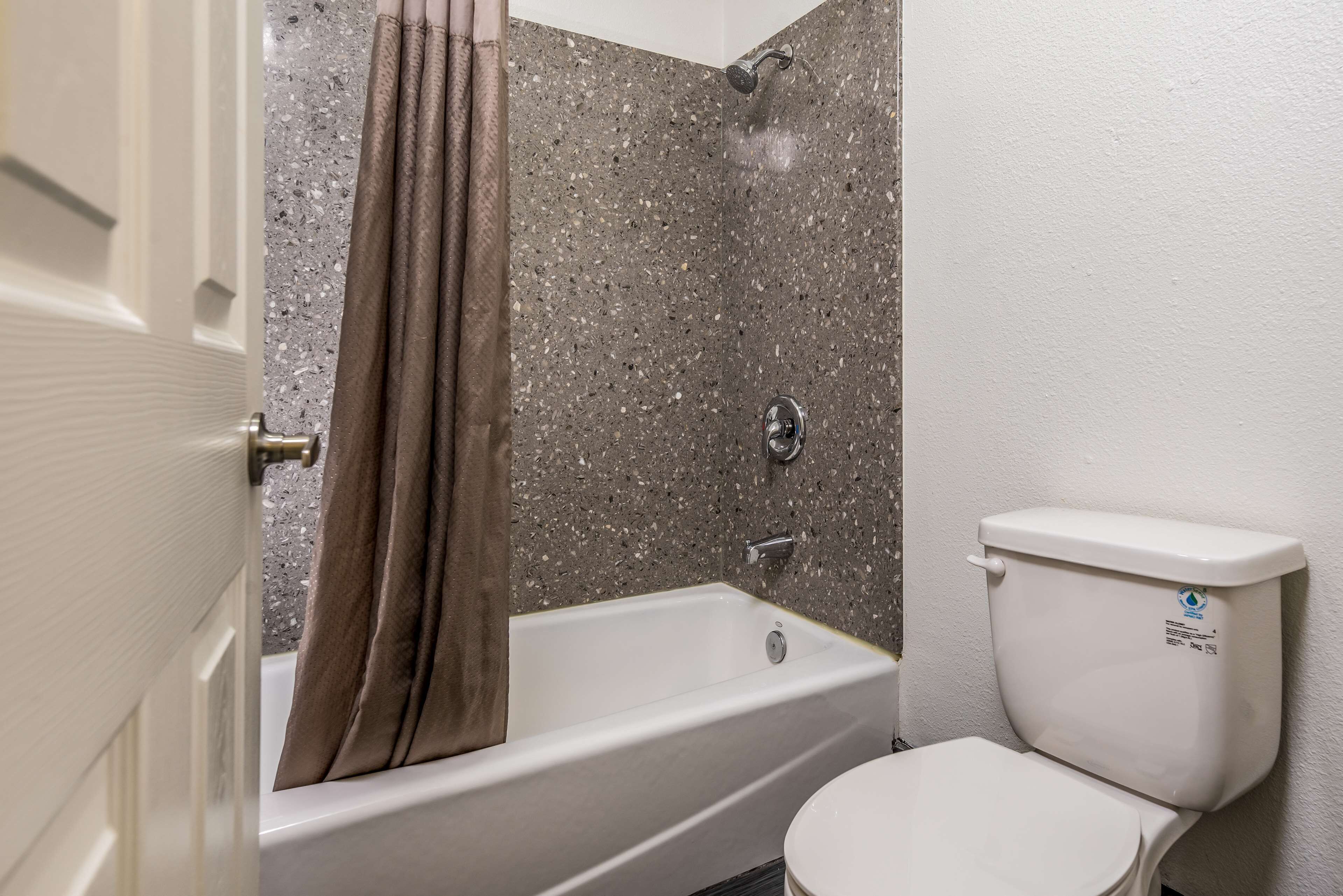 A bathroom with a bathtub, shower, and toilet.