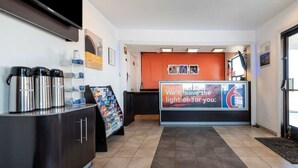 Un'area di accoglienza con reception, distributori di caffè e cartello di benvenuto.