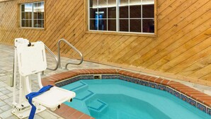 An indoor swimming pool with a wooden wall and a tiled edge. - Super 8 by Wyndham Clarinda (Clarinda)