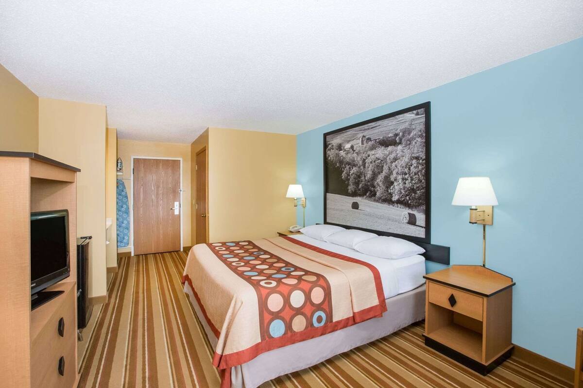 Une chambre d’hôtel équipée d’un lit, d’une télévision, d’un bureau et d’une table de chevet.