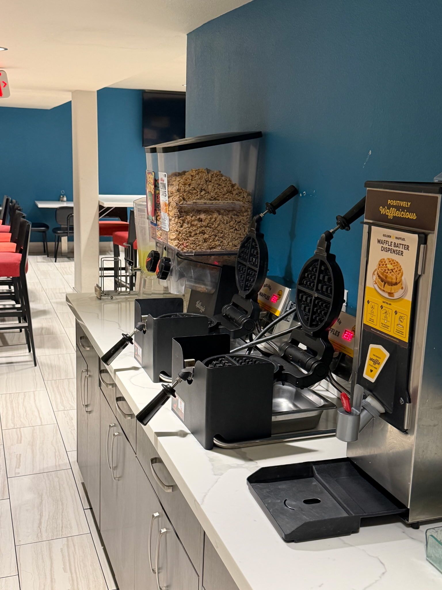 Una estación autoservicio de gofres con varias máquinas para hacer gofres y un dispensador.