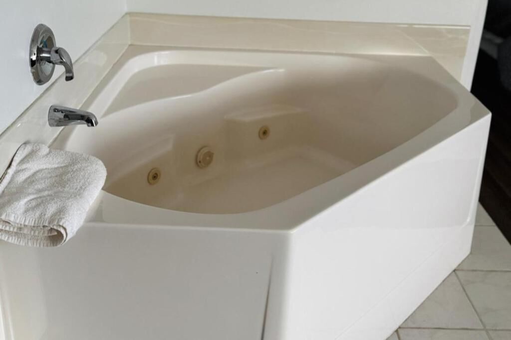 A white bathtub with a single faucet and a towel on the side.