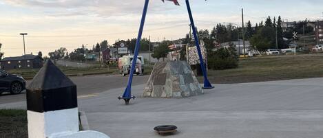 A historic mile marker sign and a welcome sign for the Alaska Highway.