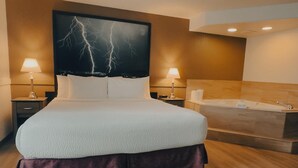 A modern hotel room with a large bed, two bedside lamps, a headboard with a lightning bolt design, a wooden floor, and a bathtub.