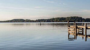 A calm lake with a wooden dock extending into the water. - Super 8 by Wyndham Manning (Manning)