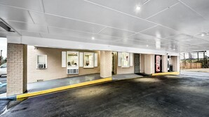 A clean, modern indoor parking area with a concrete floor and a yellow safety line. - Super 8 by Wyndham Manning (Manning)
