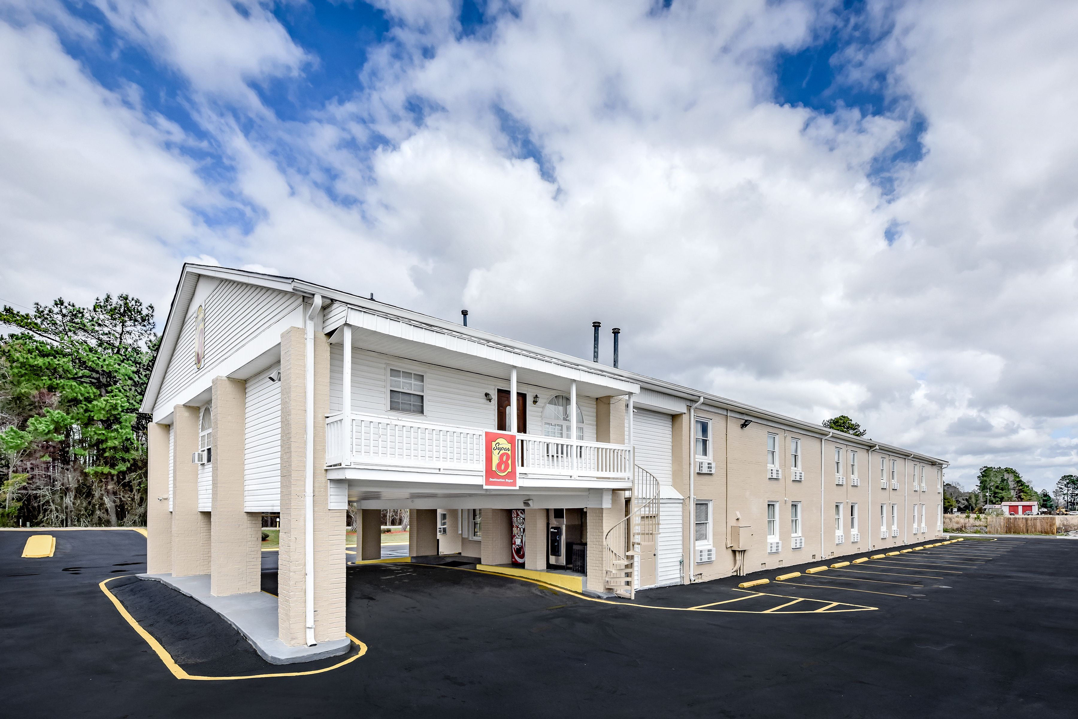 Un hôtel doté d’un toit plat, d’un balcon et d’un parking.