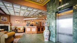 A lobby with a reception desk, a large vase, and a modern elevator. - Peterborough Inn & Suites Hotel (Peterborough)