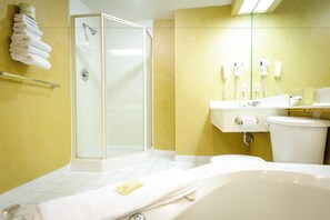 Un baño con ducha de vidrio, una bañera blanca y un lavabo con espejo.