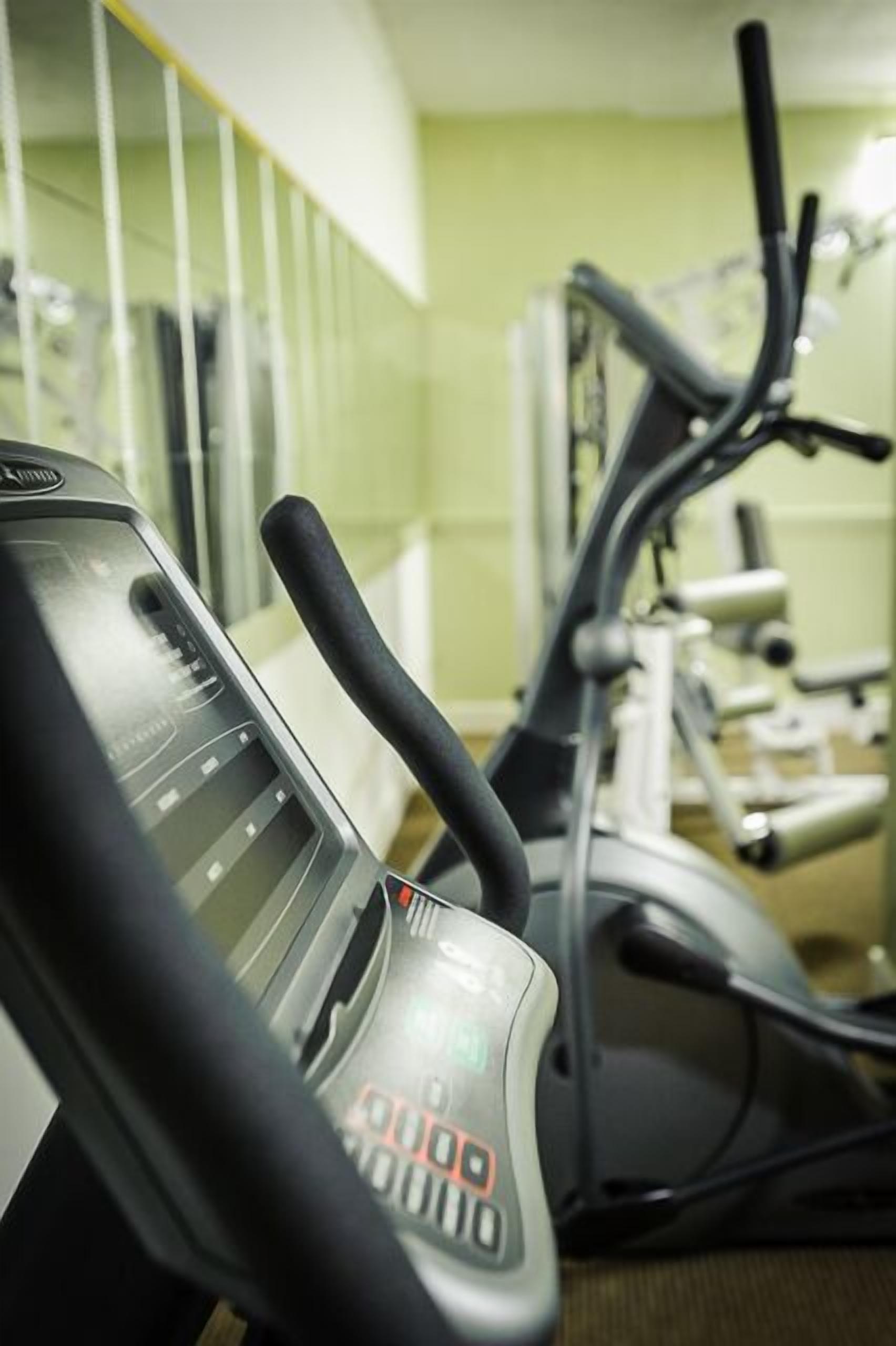 A gym with stationary bikes and a treadmill.