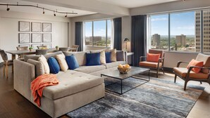 A modern living room with a sofa, armchairs, a coffee table, and a dining area with a table and chairs. - Hyatt Regency Louisville (Louisville)