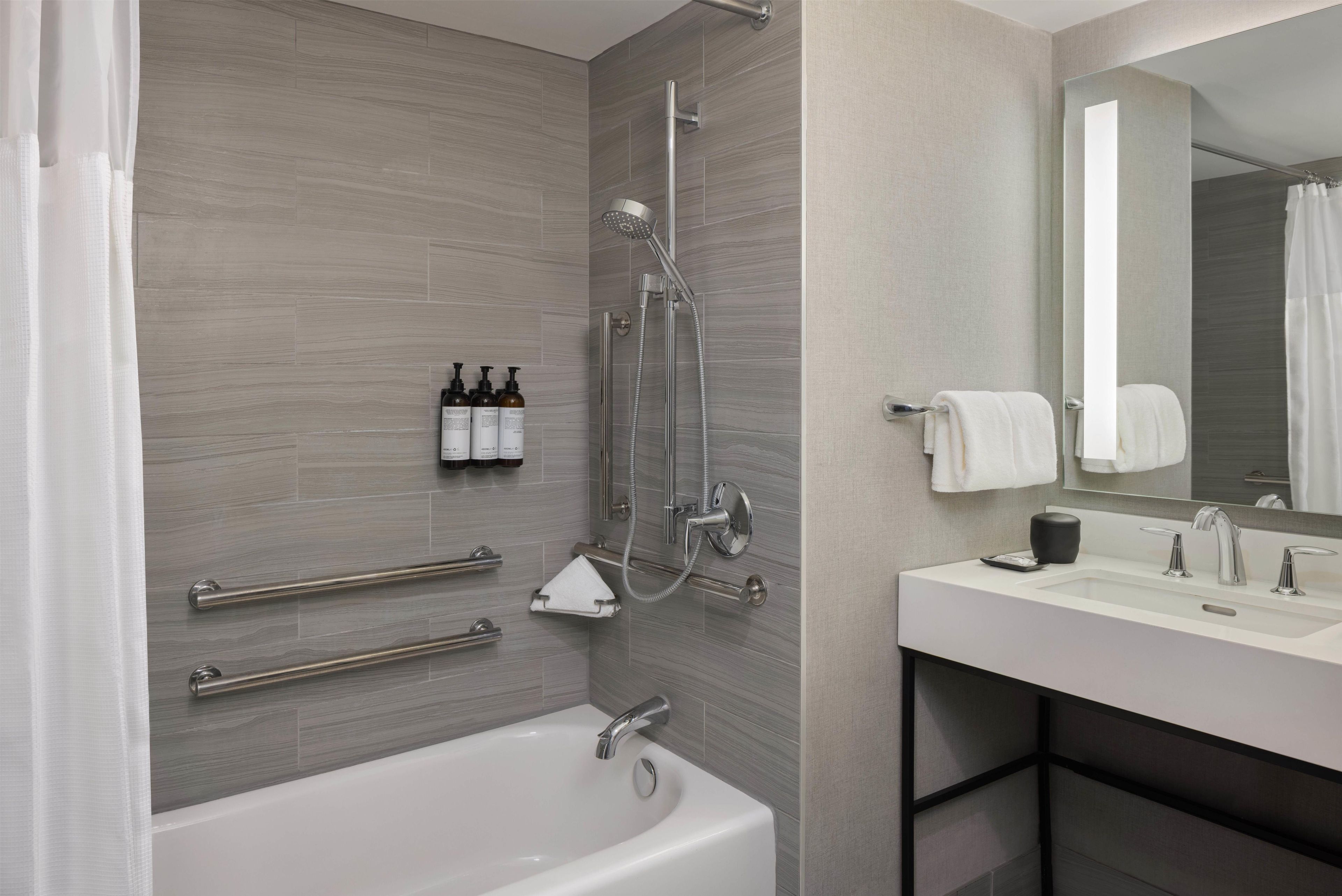 Un baño moderno con bañera, ducha y tocador con espejo.