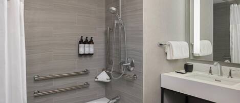 Un baño moderno con bañera, ducha y tocador con espejo.