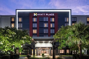 A modern Hyatt Place hotel with a prominent entrance, large windows, and a well-lit facade. - Hyatt Place Columbia/Harbison (Irmo)