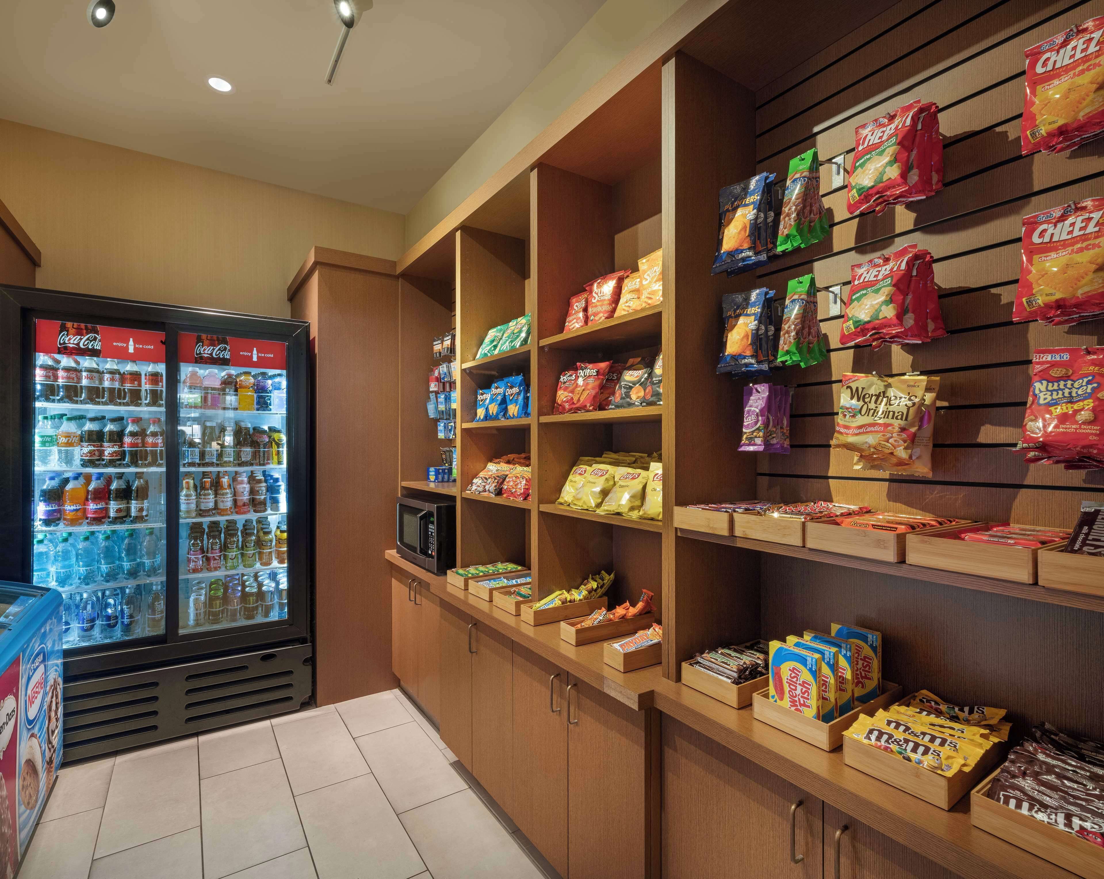 A snack and beverage display area with various packaged snacks and drinks, including chips, cookies, and bottled beverages.