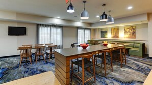 A hotel room with a dining area, a sofa, and a TV.