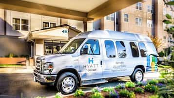 A white van with "Hyatt House" branding parked in front of a building with a sign reading "467".