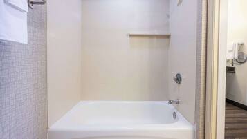 Un baño con una bañera blanca, un perchero para toallas y una zona de ducha.