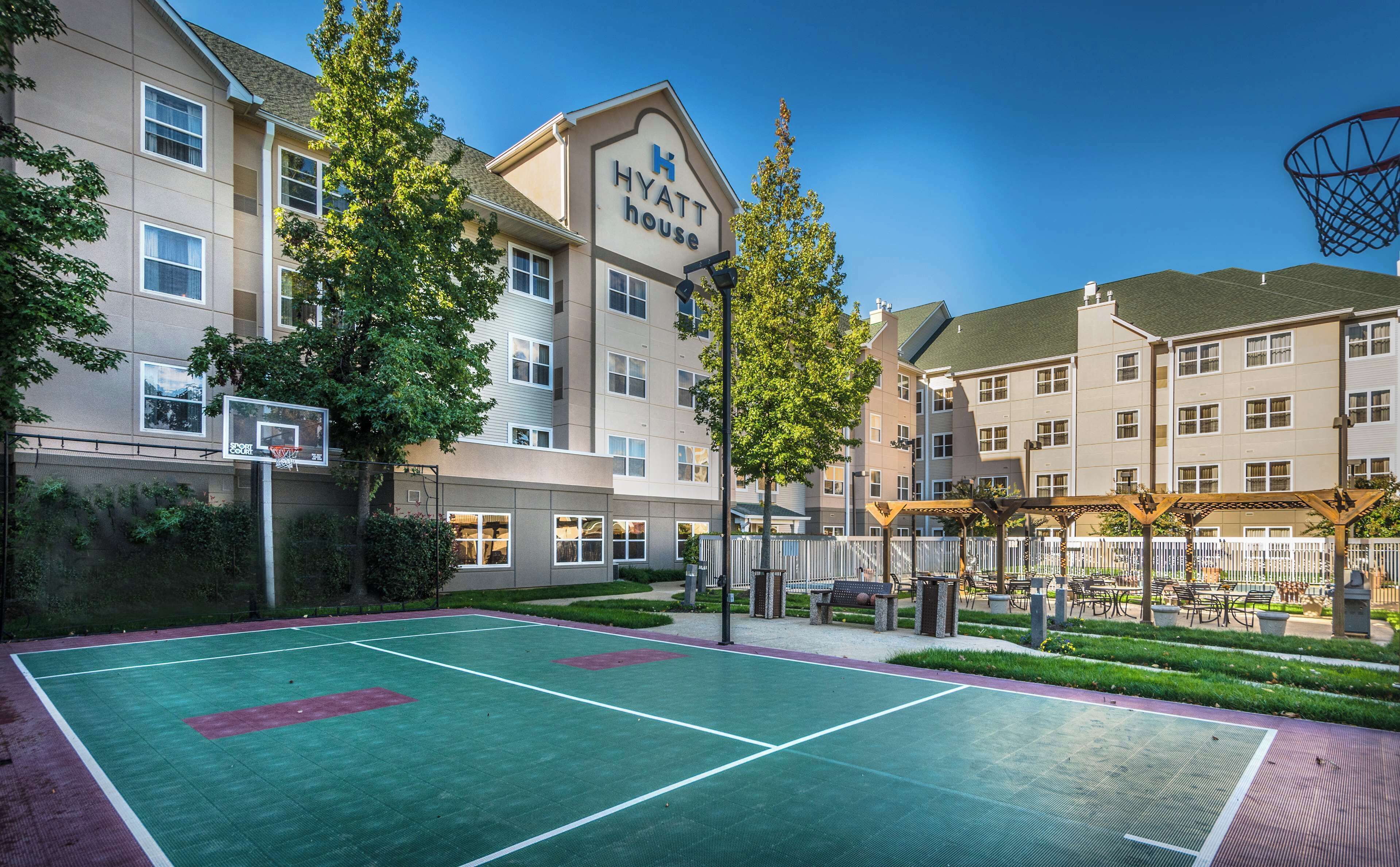 En basketballbane ved siden af et højhus, med et skilt, der viser "Hyatt House".