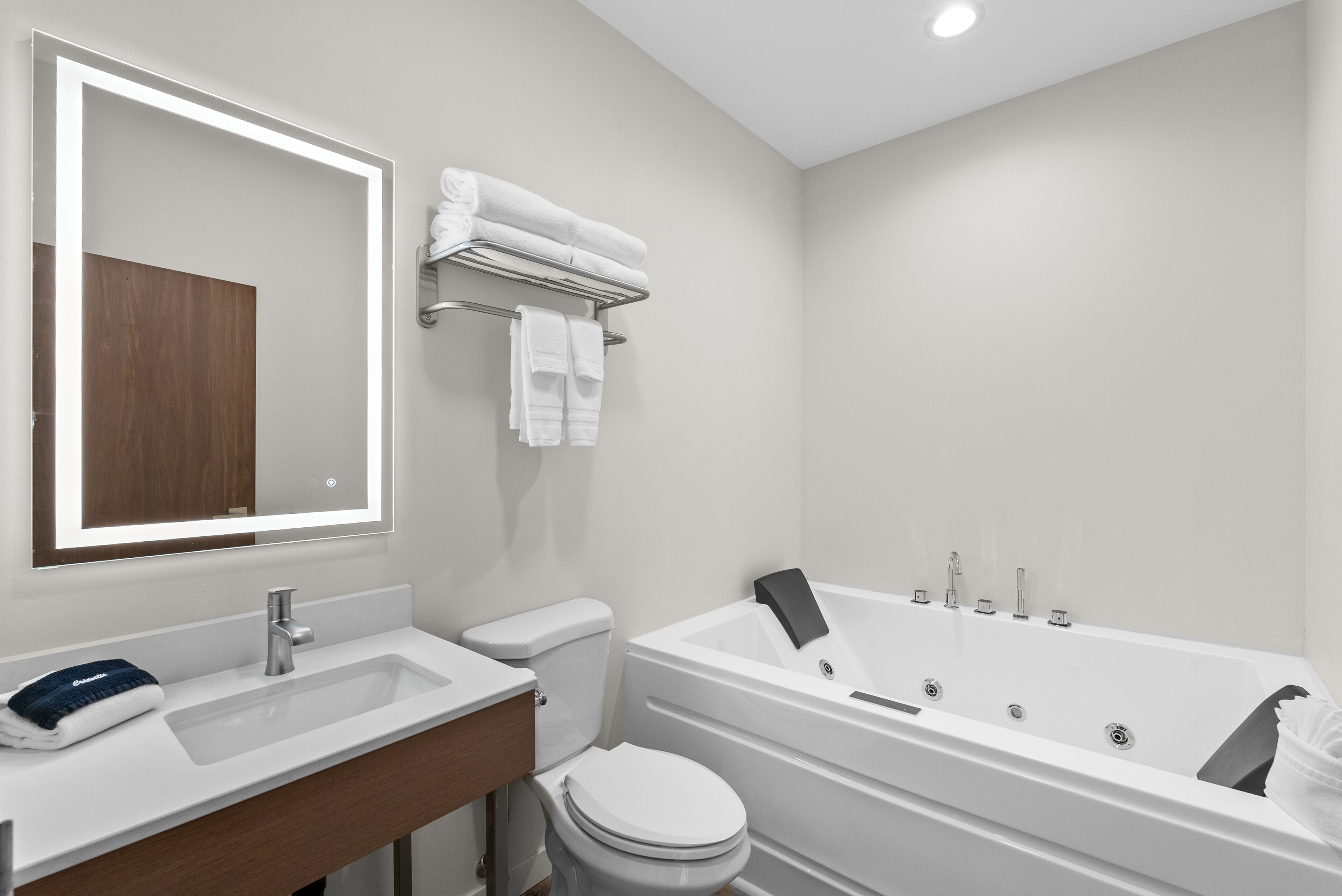 Een moderne badkamer met een wit wastafel, toilet en bad.