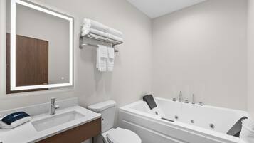 Een moderne badkamer met een wit wastafel, toilet en bad.