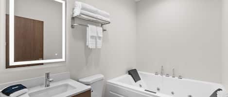 A modern bathroom with a white sink, toilet, and bathtub.