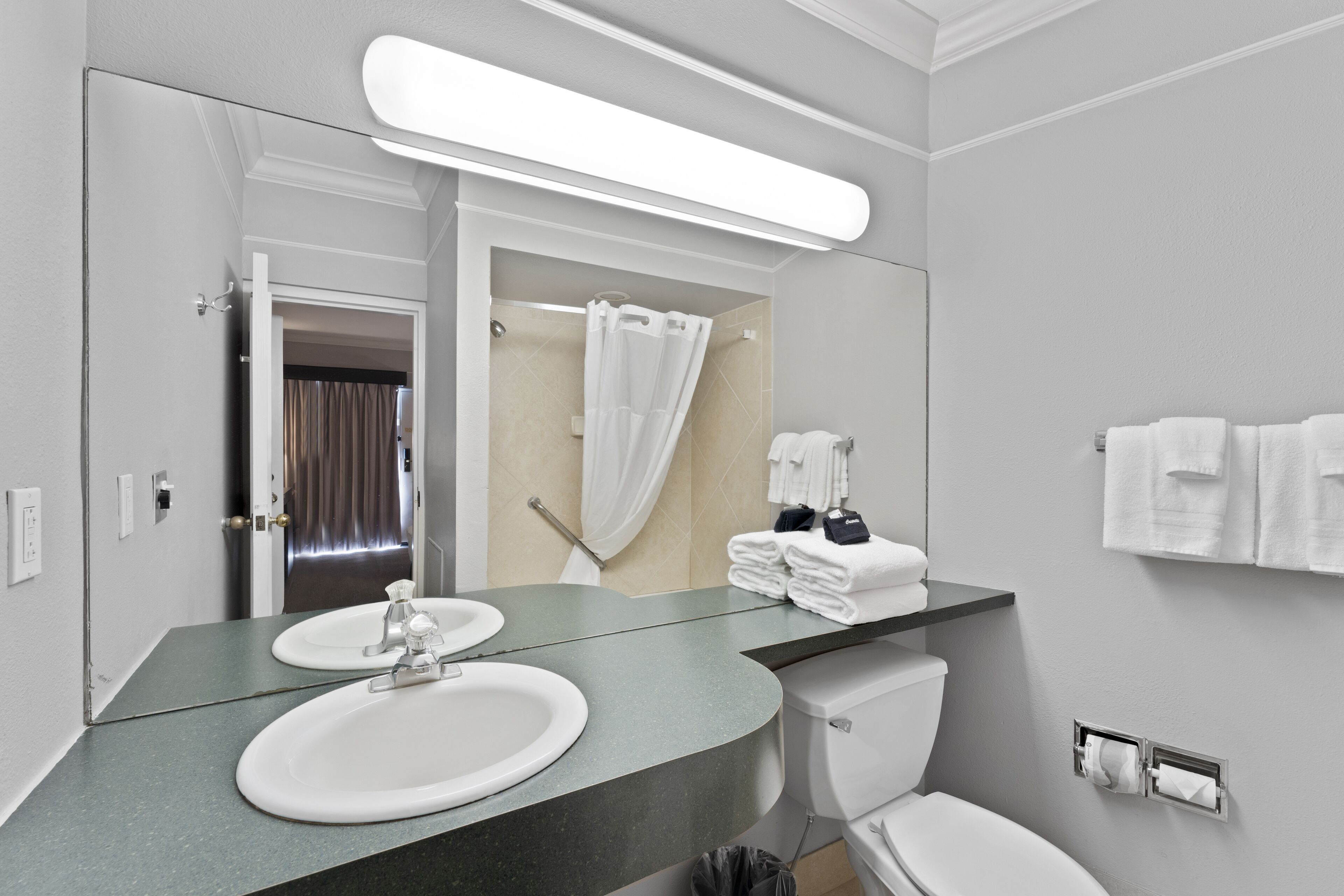 Un bagno moderno con due lavandini, un water e una doccia.