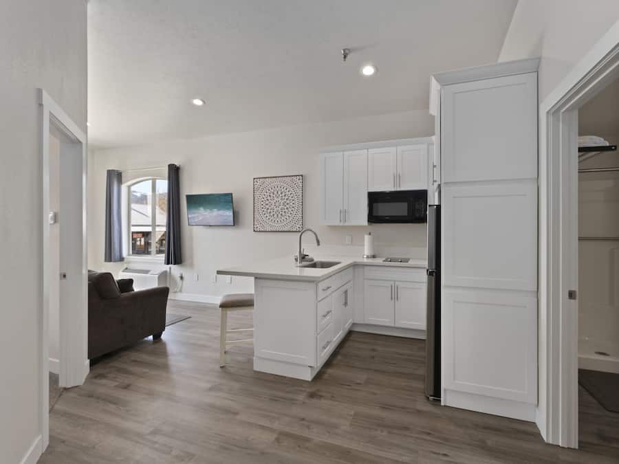 Una cocina moderna con armarios blancos, microondas integrado y una isla grande con fregadero.