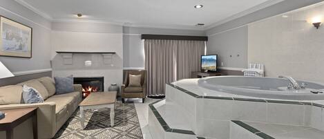 A modern living room with a fireplace, a sofa, a coffee table, and a large bathtub.