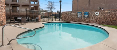 A swimming pool with a brick wall and a Cedar Street Hotel sign.