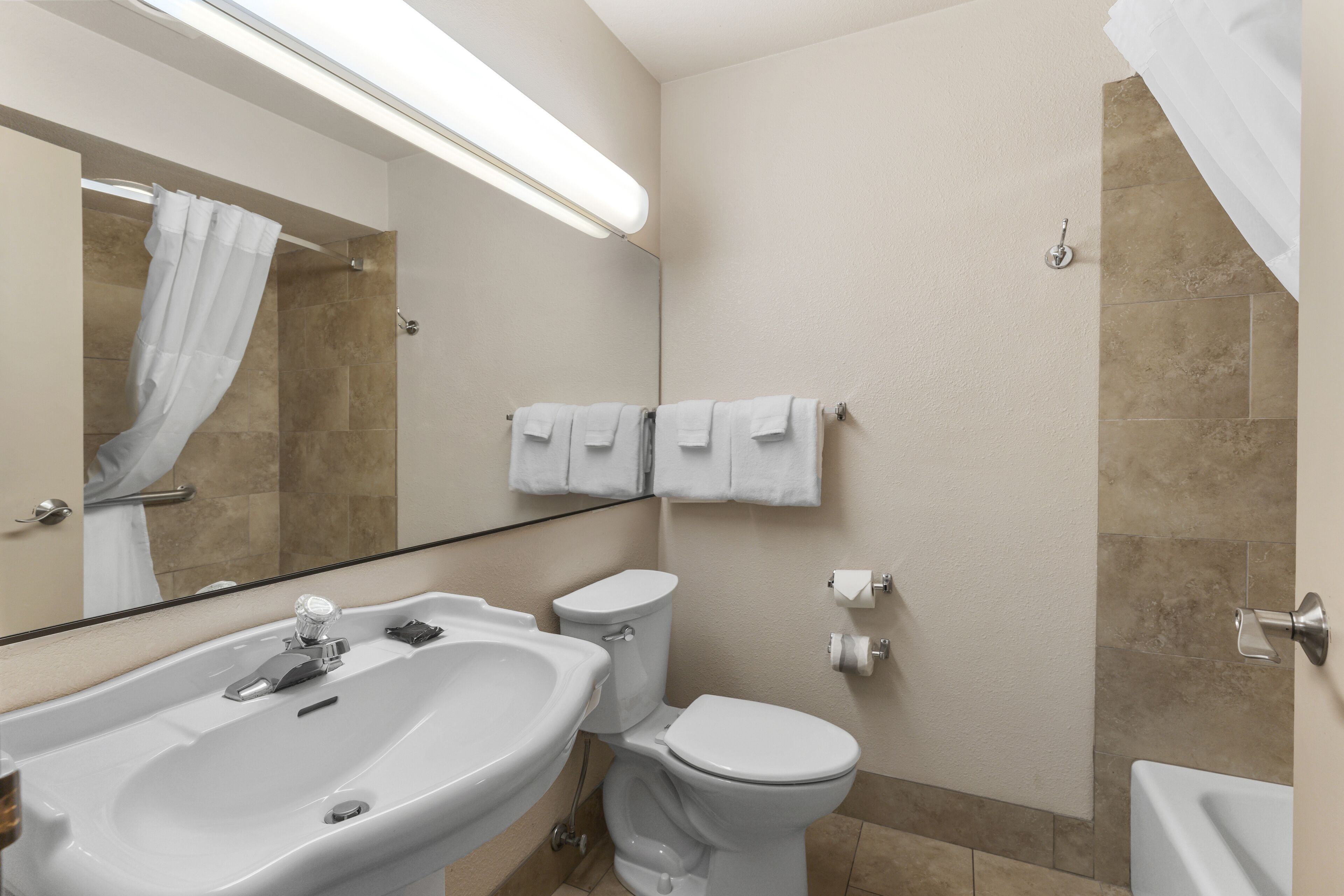 Une salle de bain moderne équipée d’un lavabo, de toilettes et d’une douche.
