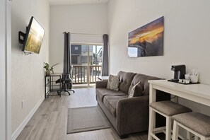 Cedar Street Suite | Living area | 65-inch flat-screen TV with cable channels