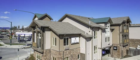 A multi-story building with a mix of brick and siding exterior, a visible garage, and a sign indicating a lobby area.