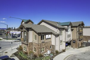 A multi-story building with a mix of brick and siding exterior, a visible garage, and a sign indicating a lobby area.