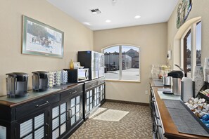 A hotel room with a kitchenette, a large window, and a view of the outside. - Sandpoint Hotel & Suites Downtown (Sandpoint)