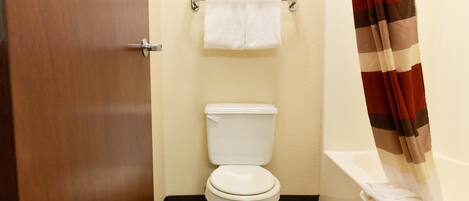 Un baño con inodoro, toallero y cortina de ducha.
