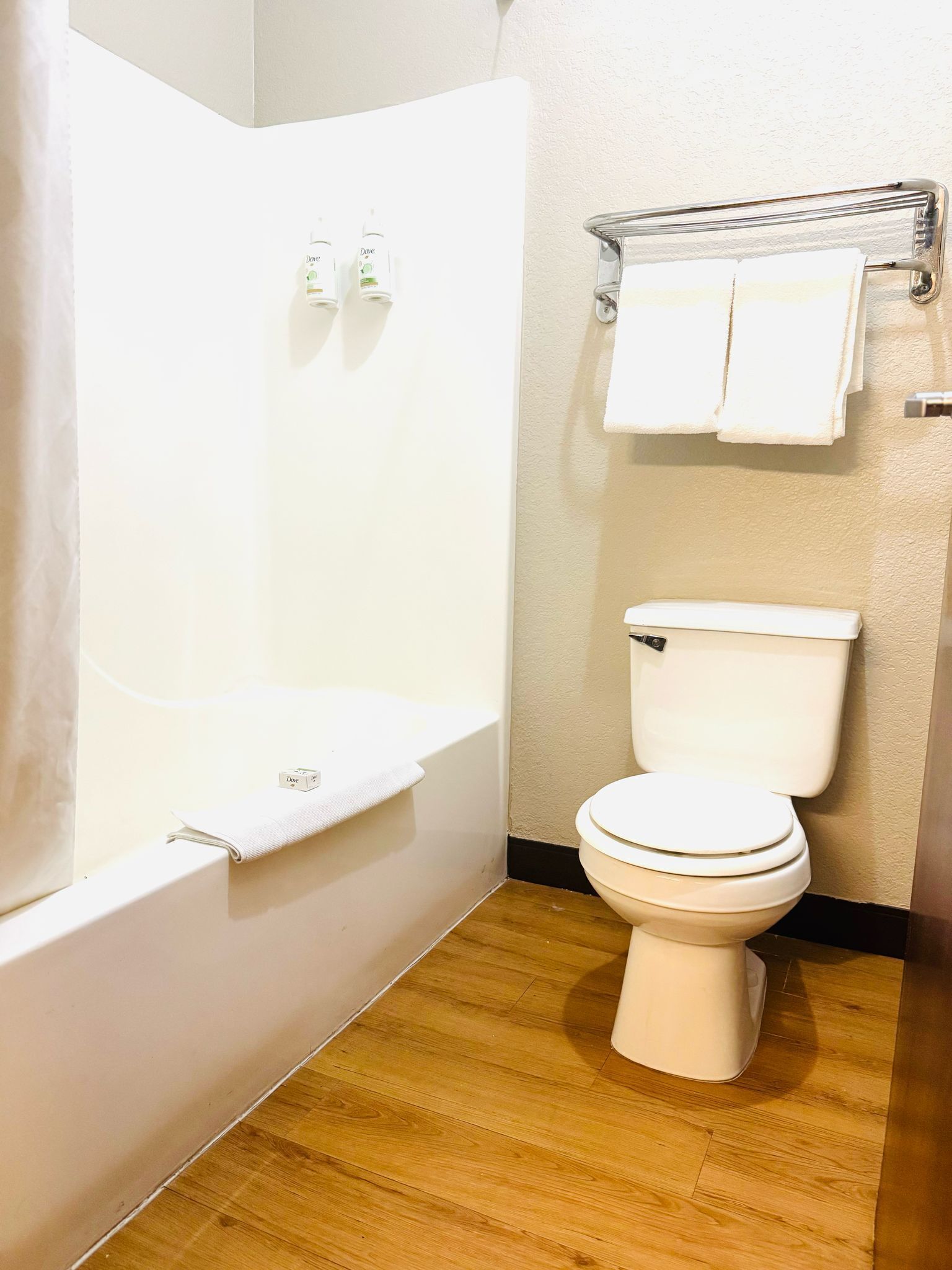 A bathroom with a bathtub, toilet, and a shower curtain.