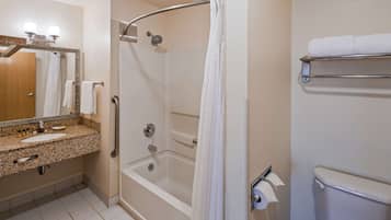 A bathroom with a shower, a sink, a toilet, and a towel rack.
