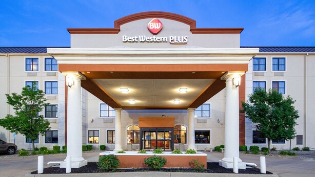 A hotel entrance with a covered walkway, columns, and a sign reading "Best Western PLUS".