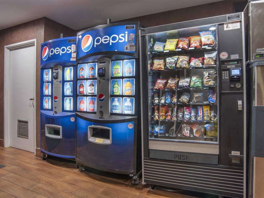 Et område med salgsautomater, herunder en med Pepsi og snacks.