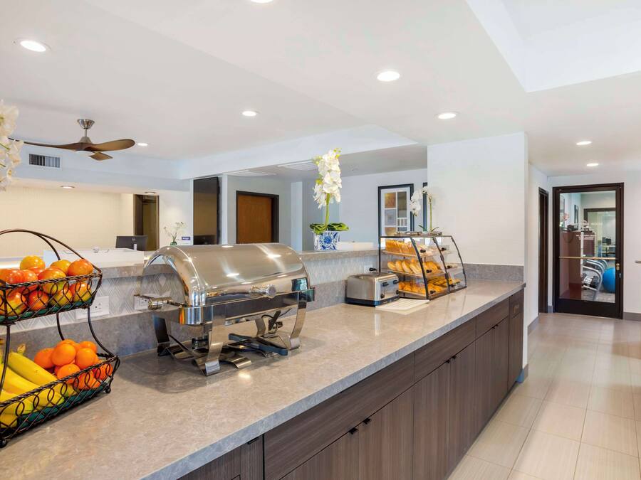 A modern kitchen with a built-in grill, fruit baskets, and a toaster.