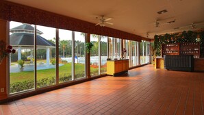 A spacious room with large windows, a tiled floor, and ceiling fans. - Quality Inn Conference Center at Citrus Hills (Hernando)