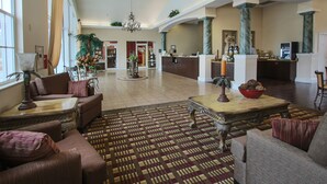 A spacious lobby with a reception desk, seating area, and decorative plants. - Quality Inn Conference Center at Citrus Hills (Hernando)